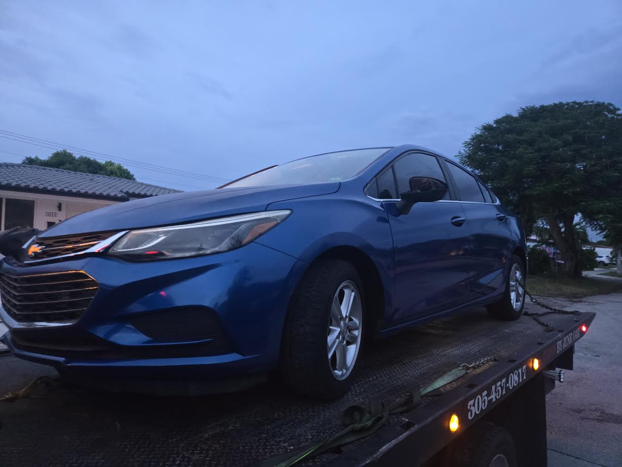 Blue Chevrolet Cruze secured on a Cash 4 Junk Cars Miami flatbed