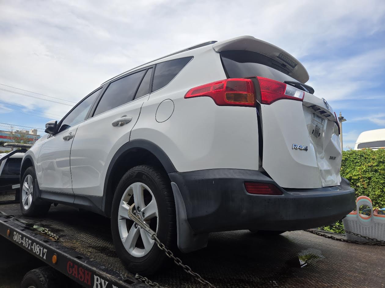 White Toyota RAV4 secured on a flatbed for vehicle pickup