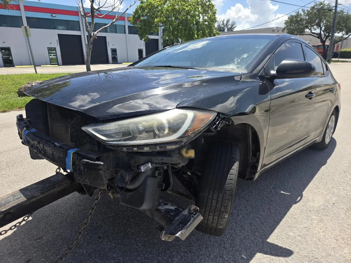 Real damaged dark sedan with missing front bumper as a junk car pickup example for Miami Gardens