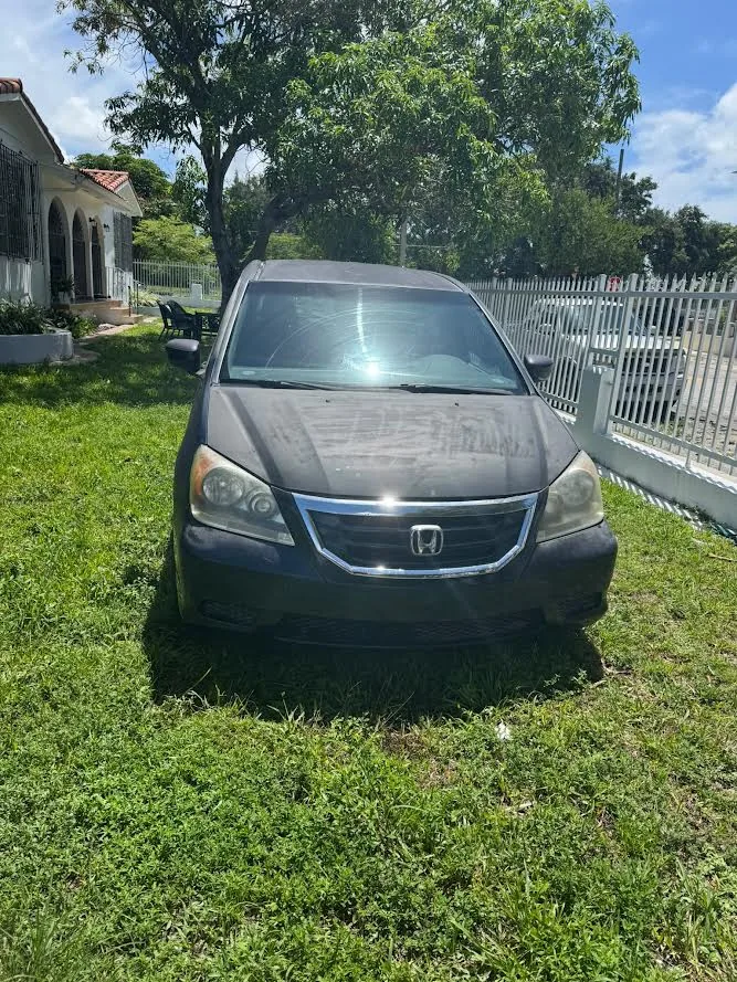 Real older Honda vehicle stored on grass as an example for junk car removal planning in Hialeah