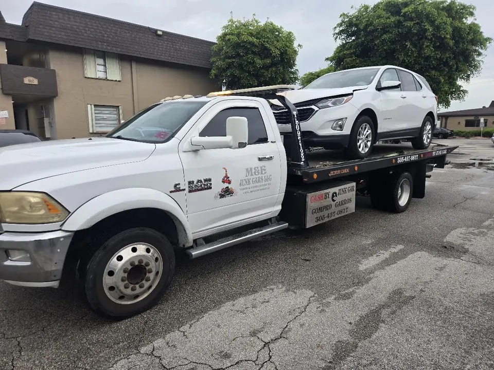 Cash 4 Junk Cars tow truck carrying a white SUV, with 305-457-0817 on its signs